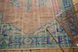Faded dusty rose field and cobalt blue palmette border detail of distressed Oushak rug.