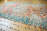 Distressed Oushak rug with soft terra cotta and sky blue floral vinery texture.