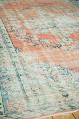 Distressed Oushak rug texture showing wear to knot heads, terra cotta, and ivory.