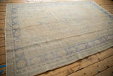 Vintage distressed Oushak carpet with faded blue geometric border and low pile texture.