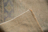 Distressed vintage Oushak rug pile texture revealing knot heads and hand-knotted foundation.