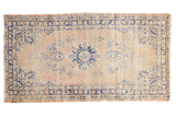 Distressed vintage Oushak runner, worn roundel medallion with navy blue vinery, blush-beige tones.
