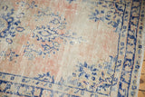 Distressed pile texture with blush, ivory, and navy cobalt blue vinery on vintage Oushak rug.