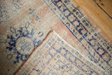 Distressed vintage Oushak rug corner revealing worn blush pile and hand-knotted foundation.