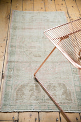 Distressed Oushak rug showing worn pile, pale pink, seafoam green, ivory tones.