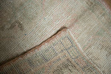 Distressed Oushak rug pile and underlying hand-knotted foundation with colored threads.