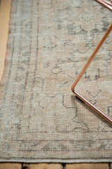 Worn texture of a distressed Oushak rug with pale sand, charcoal, and visible foundation.