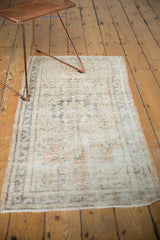 Vintage Oushak rug runner's worn texture, pale charcoal design, and secured edge.