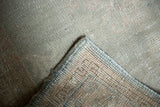 Detail of Oushak rug corner with worn dusty seafoam pile revealing hand-knotted structure.