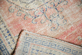 Detailed view of distressed hand-knotted Oushak rug showing worn dusty rose pile and woven reverse.