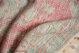 Distressed Oushak rug pile showing wear to knot heads, foundation, pale raspberry, mint.