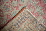 Distressed Oushak rug pile showing foundation, hand-knotted reverse and secured edge.