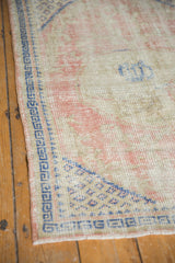 Cobalt blue geometric border and diamond lattice corner of a distressed Oushak rug.