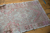 Distressed vintage Oushak runner showing soft silver, blush, and brown geometric pattern.