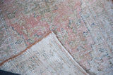 Vintage Oushak runner's distressed texture, showing wear to foundation in pink, blue, beige.