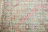Distressed Oushak rug pile with even wear, featuring soft rose, ivory, and pale green tones.