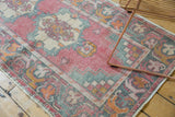 Distressed pile detail on vintage Oushak runner, revealing pale dusty rose, sea-foam green, and gold.