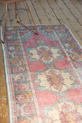 Vintage distressed Oushak runner, faded rose, ivory, sea-foam green, showing blossomed border and wear.