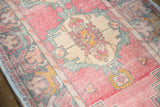 Distressed Oushak runner pile with visible knot heads, displaying faded rose and sea-foam green.