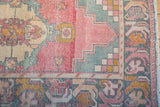 Distressed Oushak runner detail, showing faded rose field, sea-foam stepped motif, and gold border.
