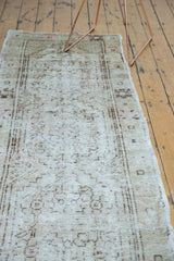 Distressed Oushak runner texture, showing faded ivory, beige, and brown geometric patterns.