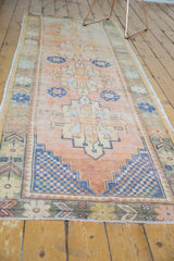 Distressed Oushak runner corner: stepped geometric border in cobalt blue and pale apricot tones.