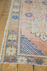 Distressed vintage Oushak rug corner showing stepped cobalt blue geometrics and muted floral border.