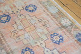 Distressed Oushak rug runner showing pale rust and cobalt blue geometric pattern with textured pile.