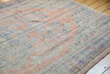 Distressed Oushak rug with faded apricot, blue, ivory pile and visible foundation wear.