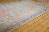 Distressed Oushak rug border with faded apricot and blue, showing even wear.