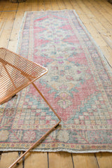 Vintage distressed Oushak runner with faded Rococo-inspired motifs in rose and ocean green.