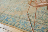 Vintage distressed Oushak carpet border, ocean blue floral vines, and soft texture.