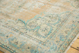 Distressed vintage Oushak carpet showing time-softened mint green and pale gold curvilinear patterns.