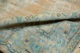 Distressed vintage Oushak pile with muted beige, pale gold, mint green, and ocean blue.