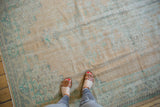 Vintage distressed Oushak carpet with even wear, faded beige and mint green texture.