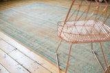 Distressed vintage Oushak rug border with faded mint green geometric motifs.