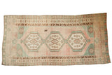 Distressed vintage Oushak runner with triple geometric medallions, faded blush, and sea foam green.