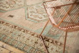 Distressed Oushak runner with pale blush, sea foam borders, meandering vine, and a spider motif.