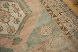 Distressed Oushak runner detail, abrashed pale blush and sea foam green field, meandering vine border.