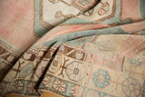 Decorative distressed Oushak runner with pale blush and sea foam green motifs.