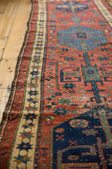 Antique Northwest Persian runner's cherry red field, blue medallion, beige star border, showing low pile.