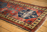 Antique Northwest Persian runner's secured side edge, geometric star border, and low pile red field.