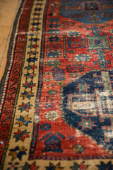 Antique Northwest Persian rug border in beige with colorful star motifs and a worn cherry red field.