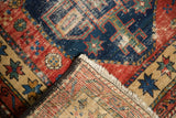 Antique Northwest Persian rug corner, hand-knotted foundation and fringe, with red, navy, beige pattern.