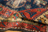 Detail of antique Northwest Persian runner's low pile, showing mostly even wear and red-blue patterns.