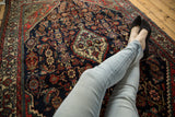 Vintage Engelas rug's navy blue and red Herati pattern beneath feet.