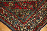 Corner of vintage Engelas rug showcasing brick red Herati field and traditional ivory border.