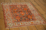 Angled perspective of a square antique Malayer rug showing its intricate coffee and orange pattern.