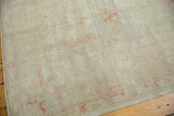 Distressed pile texture of the vintage Oushak rug with subtle terra cotta accents.