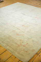 Distressed vintage Oushak rug, showing worn pale beige pile and subtle terra cotta design elements.